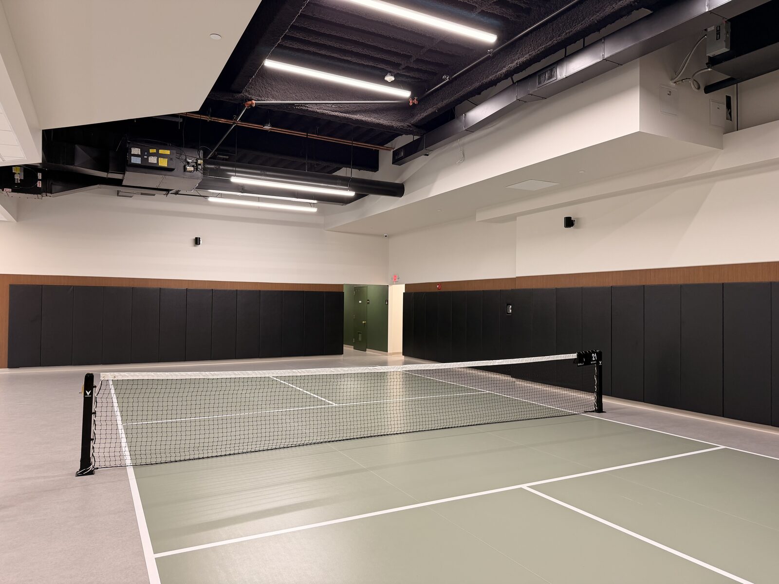 Draper wall pads lining an indoor pickleball and multi-sport court